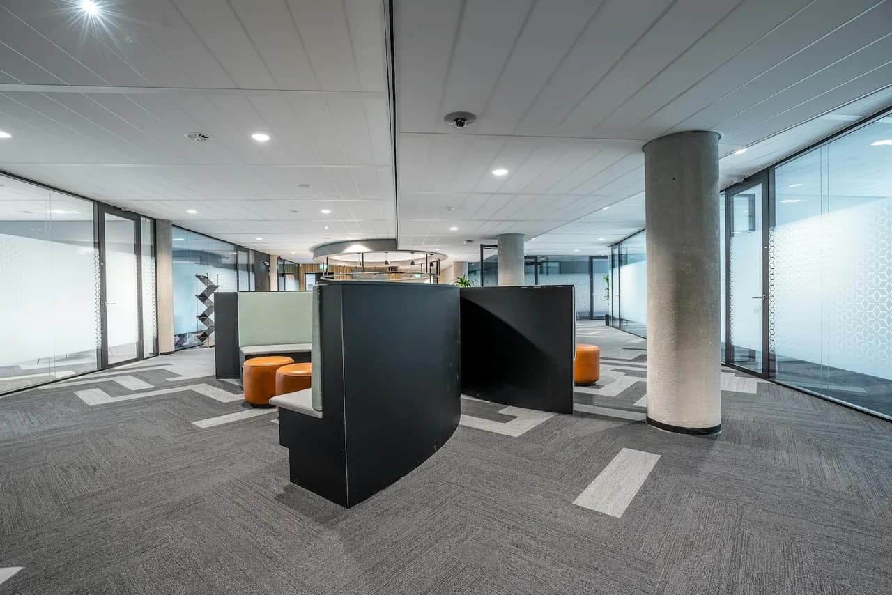 Open finished commercial interior build-out with a reception desk and structural columns