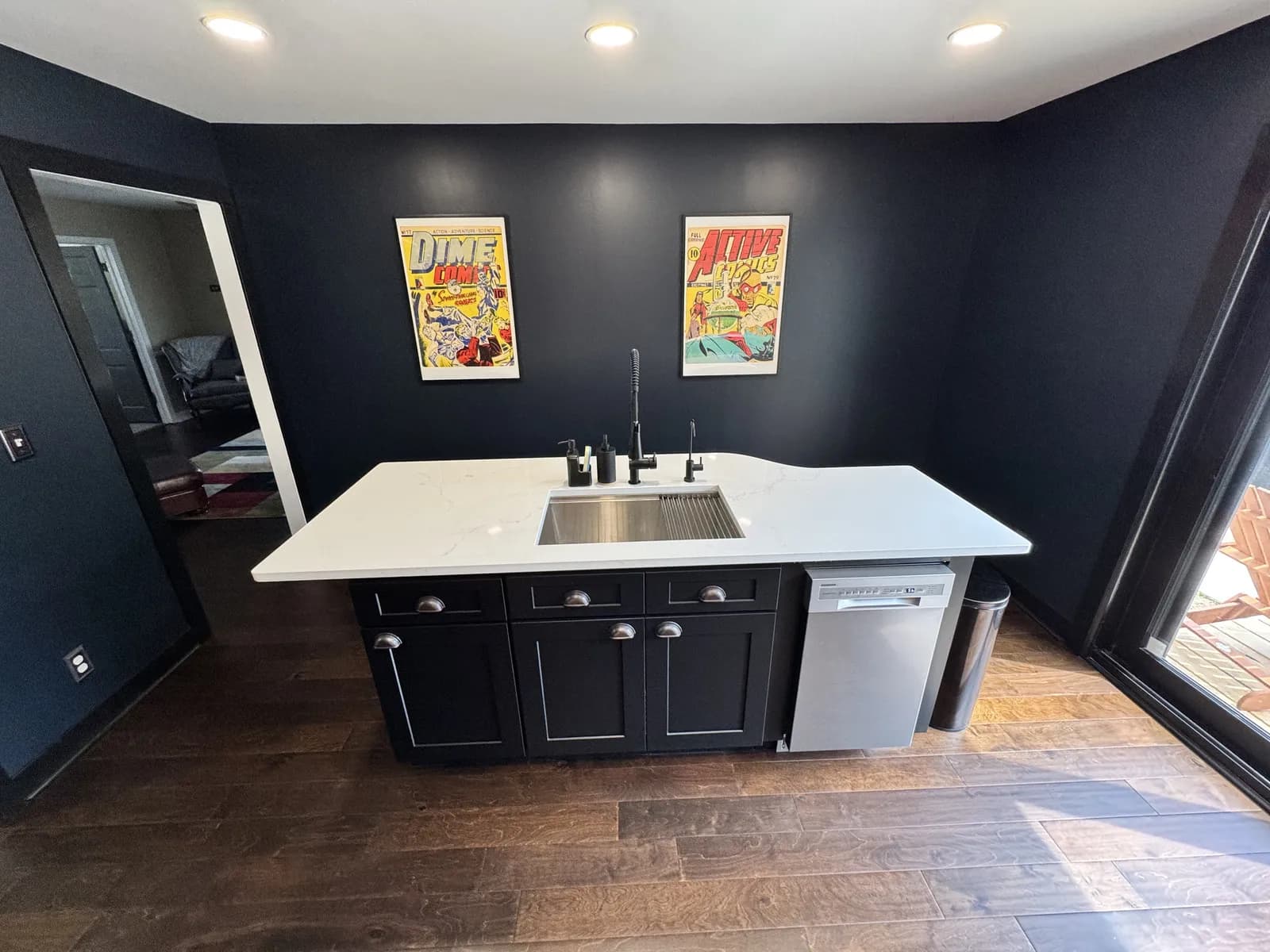 Custom home kitchen with a white waterfall island and dark cabinetry
