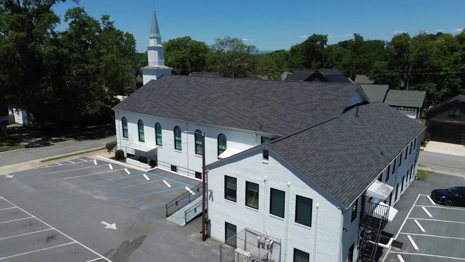 Renovated sanctuary wing of Greenville Community Church with arched windows and a white steeple